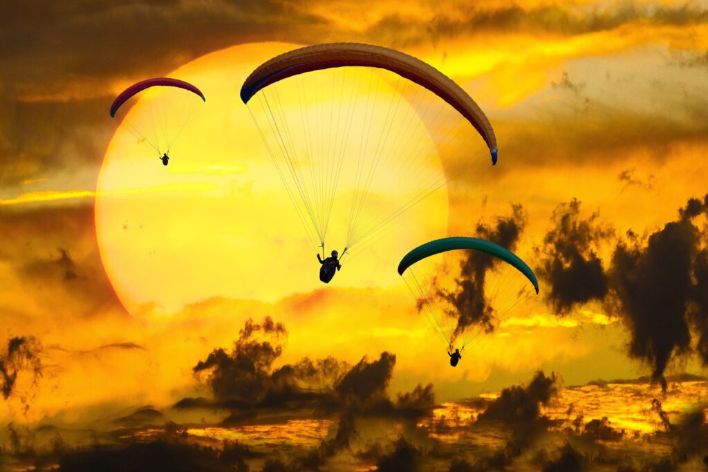 Taking ownership of choice is the start to regaining freedom. 
Paragliders above the ocean with the sunset in the background. 